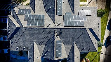 Blick von oben auf ein Haus mit mehreren Solarmodulen